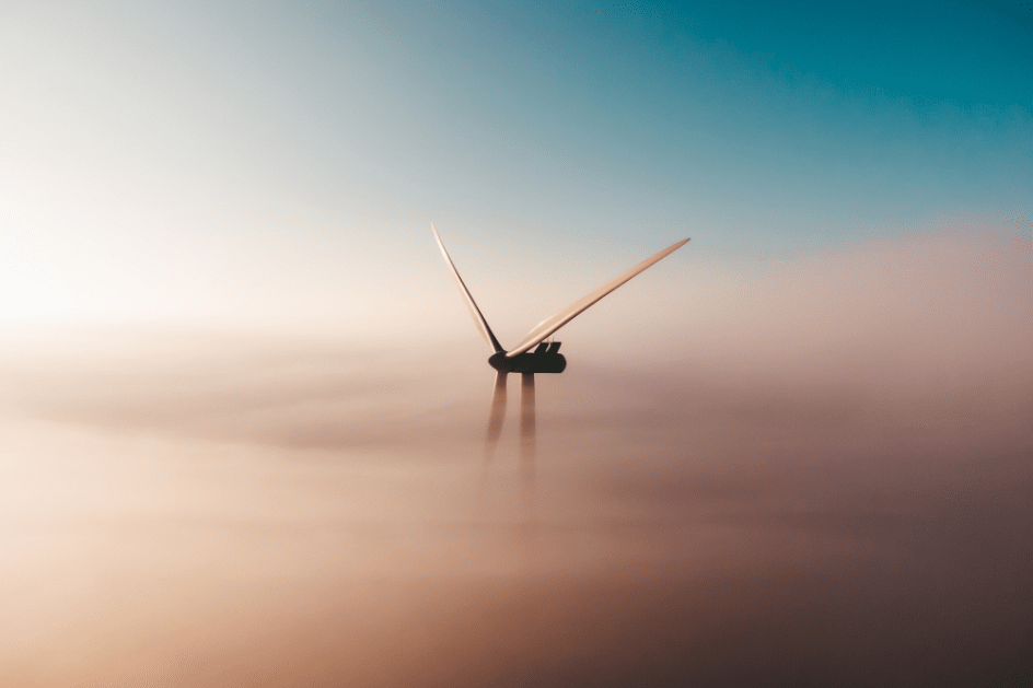 Wind power plant in a foggy background with blue and pink hues