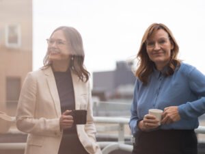 Two people smiling while holding coffee cups