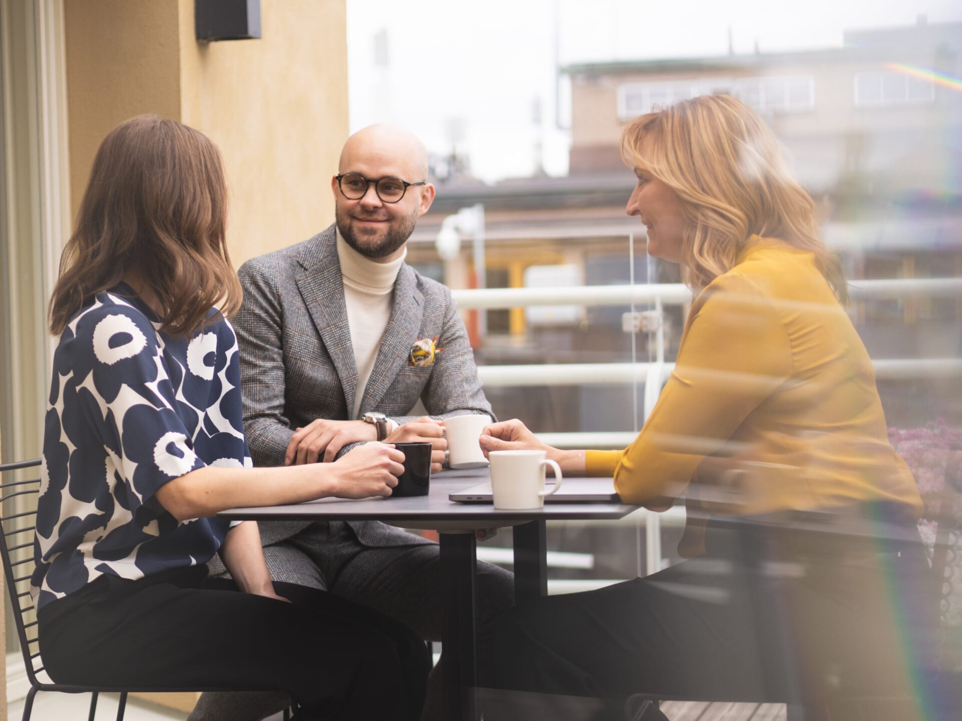 People enjoying a coffee break on a law firm's balcony