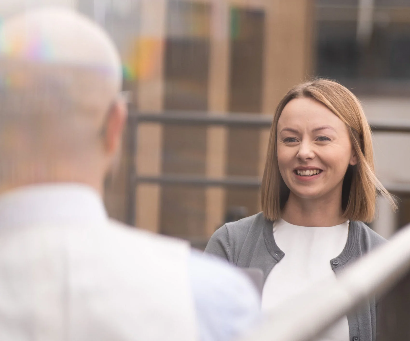 Woman smiling during a meeting on a balcony