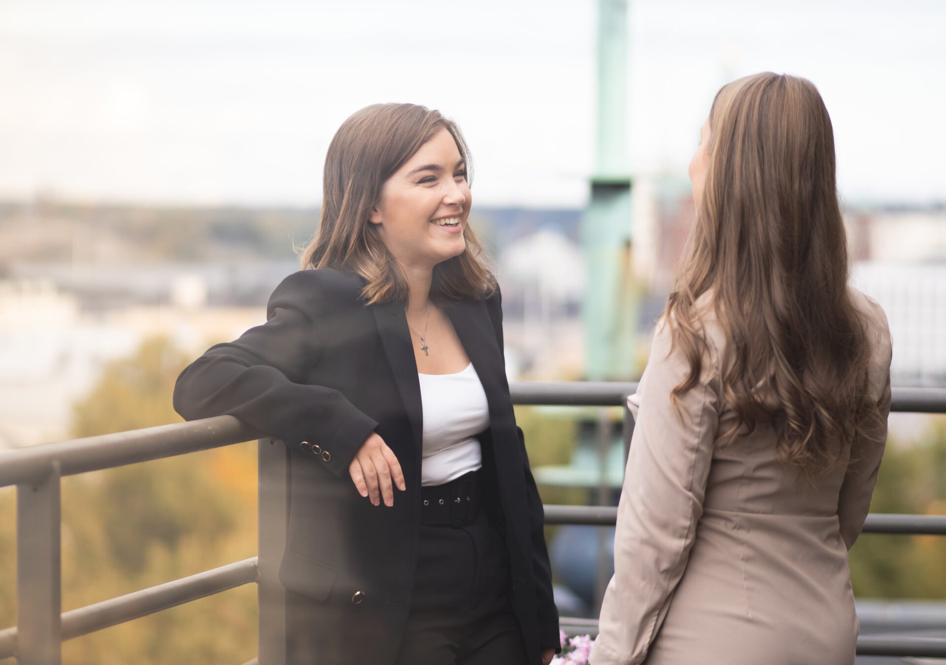 Two women colleagues smiling on the balcony of a law firm