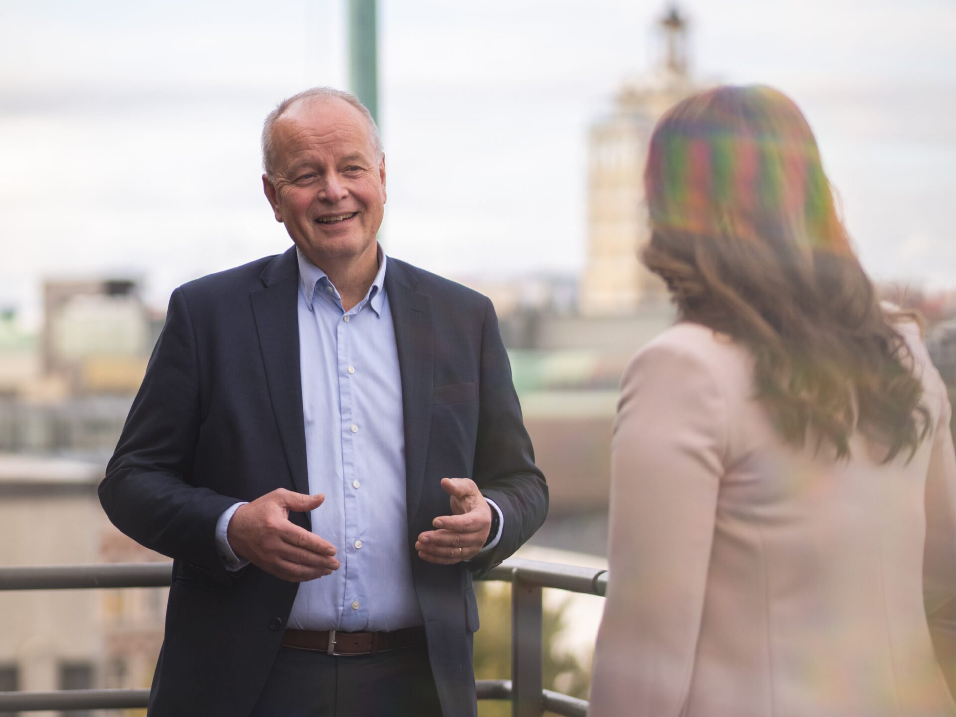 Law firm partner smiling and speaking to a colleague