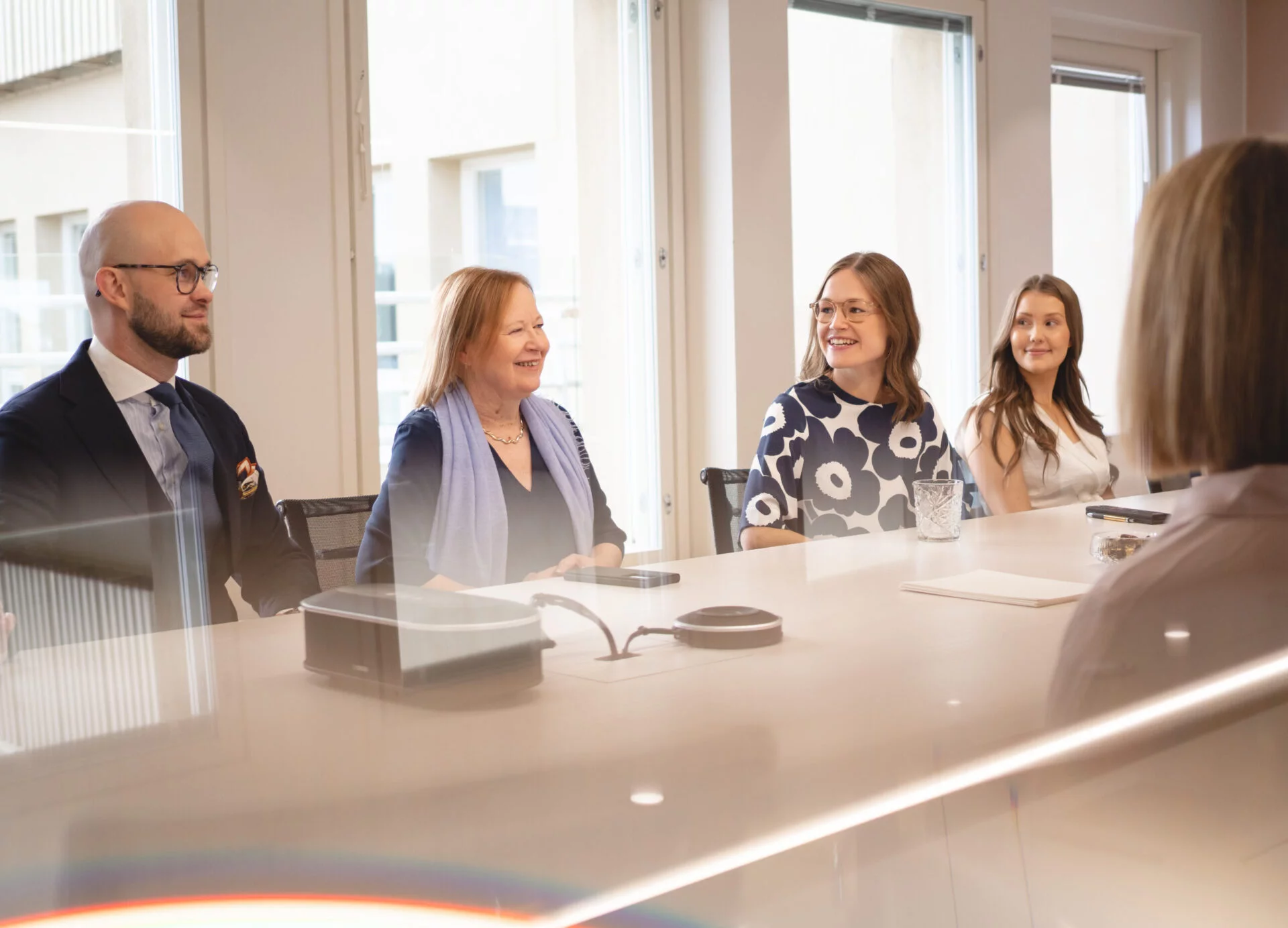 Four people smiling in a law firm's meeting room