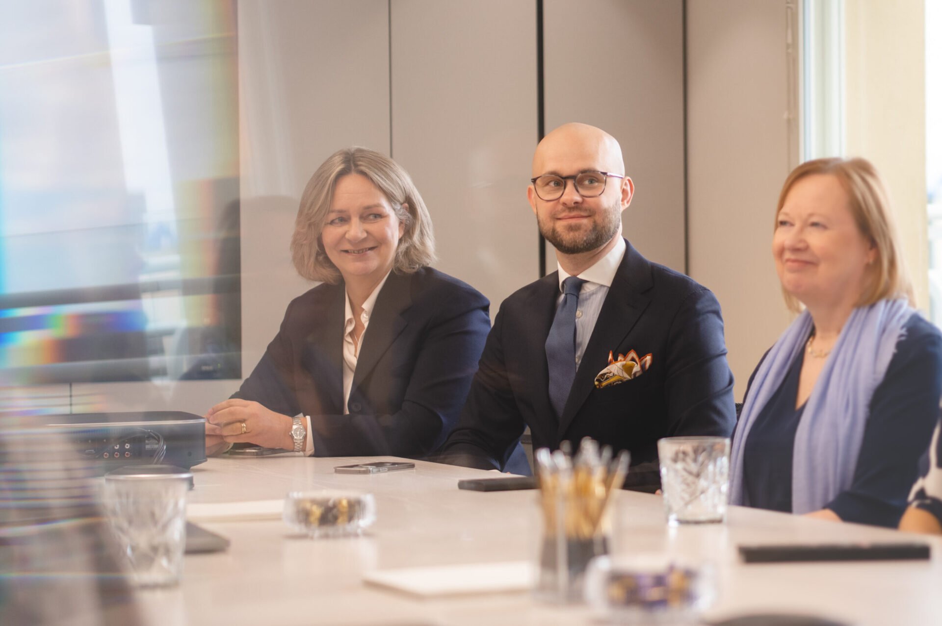 Three people smiling during a meeting in a law firm