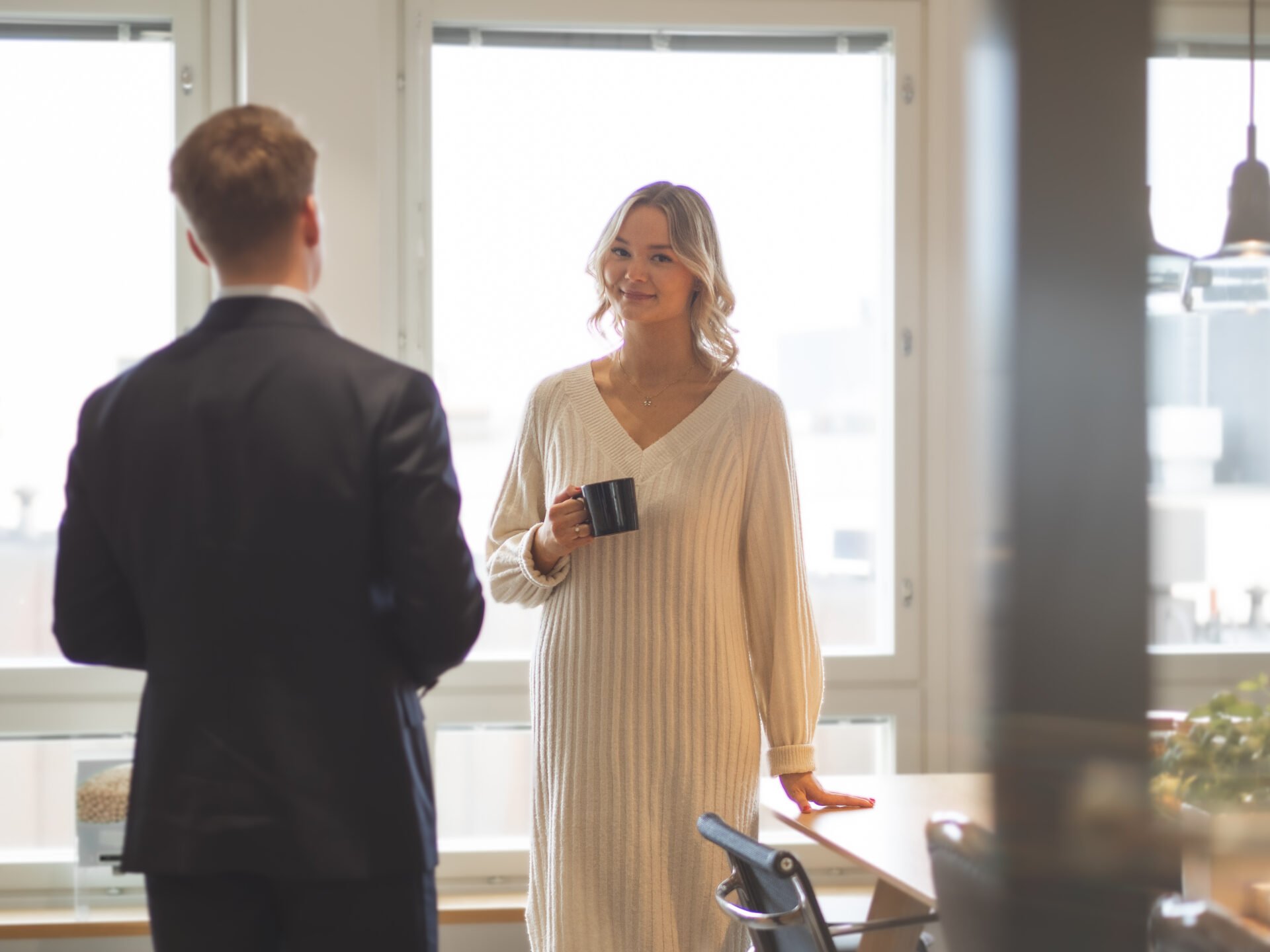 Smiling woman holding a coffee cup in a law firm's break room